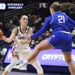 
              Connecticut's Nika Muhl (10) passes around Creighton's Molly Mogensen (21) in the first half of an NCAA college basketball game, Sunday, Jan. 9, 2022, in Storrs, Conn. (AP Photo/Jessica Hill)
            
