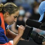 
              Madison Keys of the U.S. autographs a tv camera after defeating compatriot Sofia Kenin in their first round match at the Australian Open tennis championships in Melbourne, Australia, Monday, Jan. 17, 2022. (AP Photo/Andy Brownbill)
            