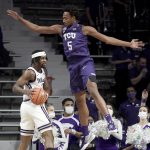 
              Kansas State guard Selton Miguel, left, looks to pass around TCU forward Chuck O'Bannon Jr. (5) during the first half of an NCAA college basketball game Wednesday, Jan. 12, 2022, in Manhattan, Kan. (AP Photo/Charlie Riedel)
            