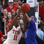 
              Texas Tech's Bryson Williams (11) and Kansas' Dajuan Harris Jr. (3) fight for control of the ball during the first half of an NCAA college basketball game on Saturday, Jan. 8, 2022, in Lubbock, Texas. (AP Photo/Brad Tollefson)
            