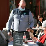 
              A waiter checks clients' vaccine passes at a restaurant in Saint Jean de Luz, southwestern France, Monday, Jan. 24, 2022. Unvaccinated people are no longer allowed in France's restaurants, bars, tourist sites and sports venues, as a new law came into effect Monday requiring a "vaccine pass" that is central to the government's anti-virus strategy. (AP Photo/Bob Edme)
            