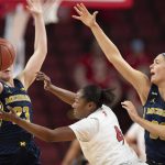 
              Michigan's Danielle Rauch (23) and Emily Kiser (33) reach for a loose ball against Nebraska's Sam Haiby (4) during the first half of an NCAA college basketball game Tuesday, Jan. 4, 2022, in Lincoln, Neb. (AP Photo/Rebecca S. Gratz)
            