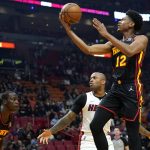
              Atlanta Hawks forward De'Andre Hunter (12) goes to the basket as Miami Heat forward P.J. Tucker defends during the first half of an NBA basketball game, Friday, Jan. 14, 2022, in Miami. (AP Photo/Lynne Sladky)
            