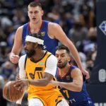 
              Utah Jazz guard Mike Conley looks to pass the ball as Denver Nuggets guard Facundo Campazzo, right, and center Nikola Jokic defend during the first half of an NBA basketball game Wednesday, Jan. 5, 2022, in Denver. (AP Photo/David Zalubowski)
            