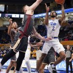 
              Pittsburgh's Femi Odukale (2) shoots as Boston College's James Karnik, front left, defends during the first half of an NCAA college basketball game, Saturday, Jan. 8, 2022, in Pittsburgh. (AP Photo/Keith Srakocic)
            