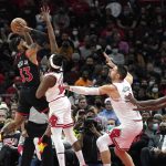 
              Toronto Raptors' Gary Trent Jr. (33) shoots over Chicago Bulls' Ayo Dosunmu as Nikola Vucevic also defends during the second half of an NBA basketball game Wednesday, Jan. 26, 2022, in Chicago. The Bulls won 111-105. (AP Photo/Charles Rex Arbogast)
            