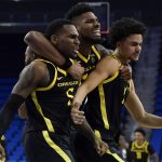 
              From left, Oregon guard De'Vion Harmon, forward Quincy Guerrier, and guard Will Richardson celebrate after winning 84-81 in overtime of an NCAA college basketball game against UCLA in Los Angeles, Thursday, Jan. 13, 2022. (AP Photo/Ashley Landis)
            