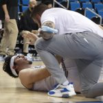 
              UCLA guard Jaime Jaquez Jr. (24) receives attention for an injury during the first half of the team's NCAA college basketball game against Long Beach State on Thursday, Jan. 6, 2022, in Los Angeles. (AP Photo/Ringo H.W. Chiu)
            
