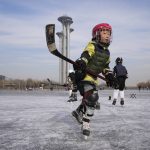 
              A child practices ice hockey near the Beijing Olympics Tower in Beijing, China, Tuesday, Jan. 18, 2022. The Beijing Winter Olympics is tapping into and encouraging growing interest among Chinese in skiing, skating, hockey and other previously unfamiliar winter sports. It's also creating new business opportunities (AP Photo/Ng Han Guan)
            