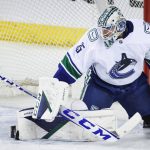 
              Vancouver Canucks goalie Thatcher Demko deflects a shot during the second period of an NHL hockey game against the Calgary Flames Saturday, Jan. 29, 2022 in Calgary, Alberta. (Jeff McIntosh/The Canadian Press via AP)
            