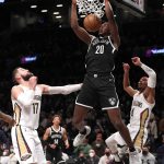 
              Brooklyn Nets center Day'Ron Sharpe (20) dunks against New Orleans Pelicans center Jonas Valanciunas (17) and guard Devonte' Graham (4) during the first half of an NBA basketball game, Saturday, Jan. 15, 2022, in New York. (AP Photo/Noah K. Murray)
            