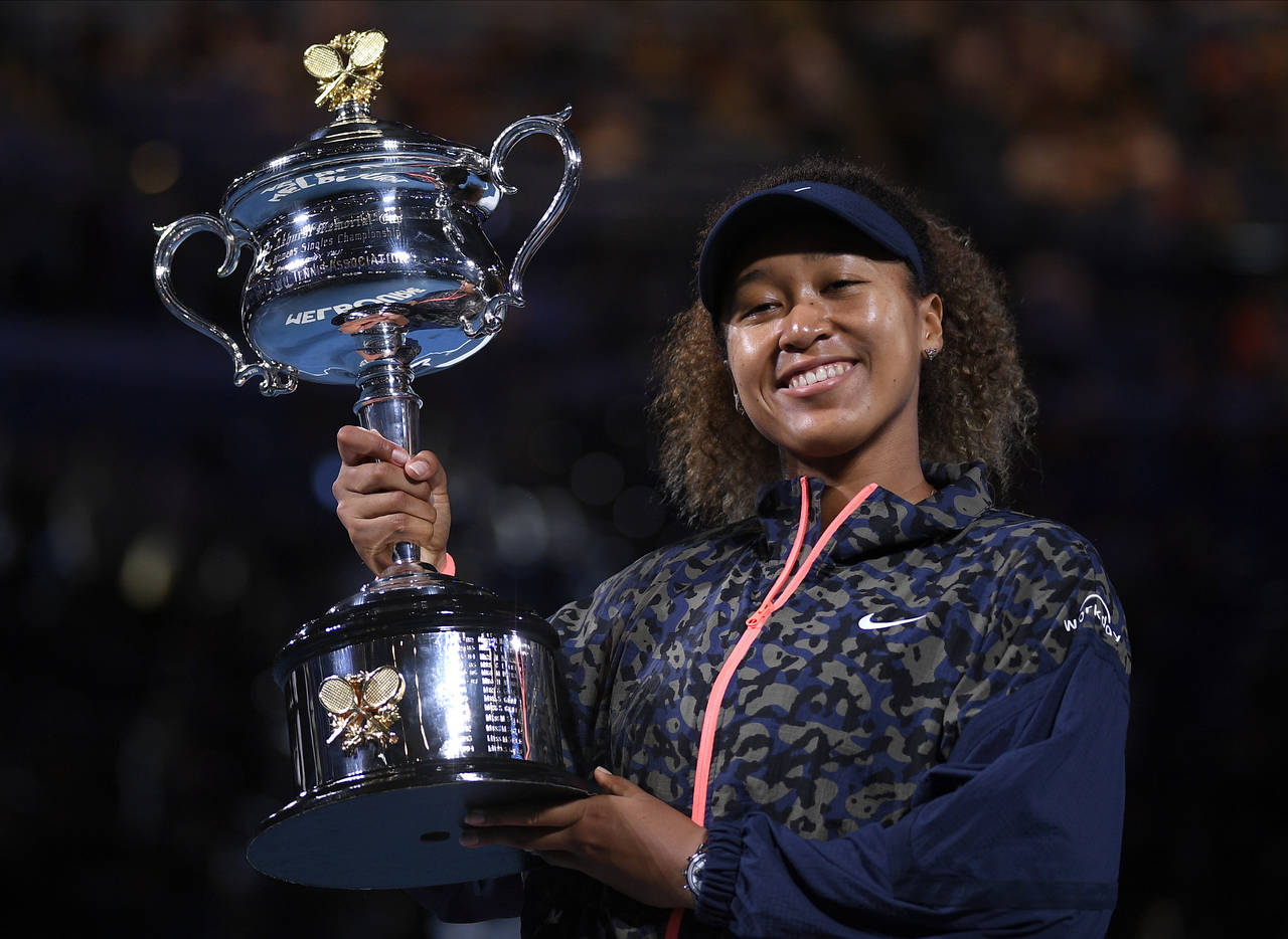 FILE - Japan's Naomi Osaka holds the Daphne Akhurst Memorial Cup aloft after defeating United State...