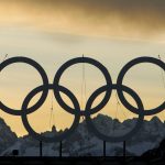 
              FILE - Large Olympic rings are seen at sunset on the roof of the hotel being used as the athlete's village for the alpine events in the village of Sestriere, northern Italy, Feb. 2, 2006. (AP Photo/Kevin Frayer, File)
            