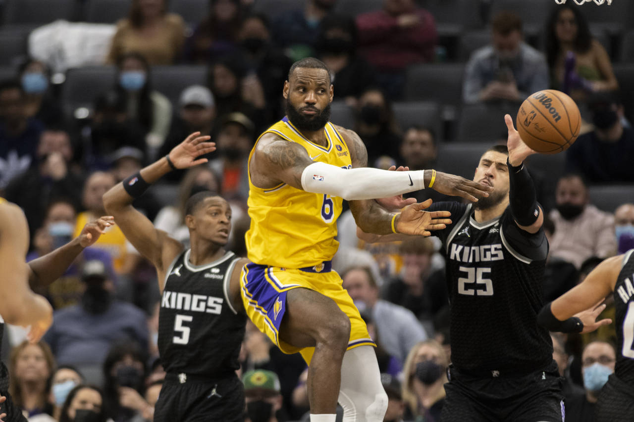 Los Angeles Lakers forward LeBron James (6) passes off while defended by Sacramento Kings guard De'...