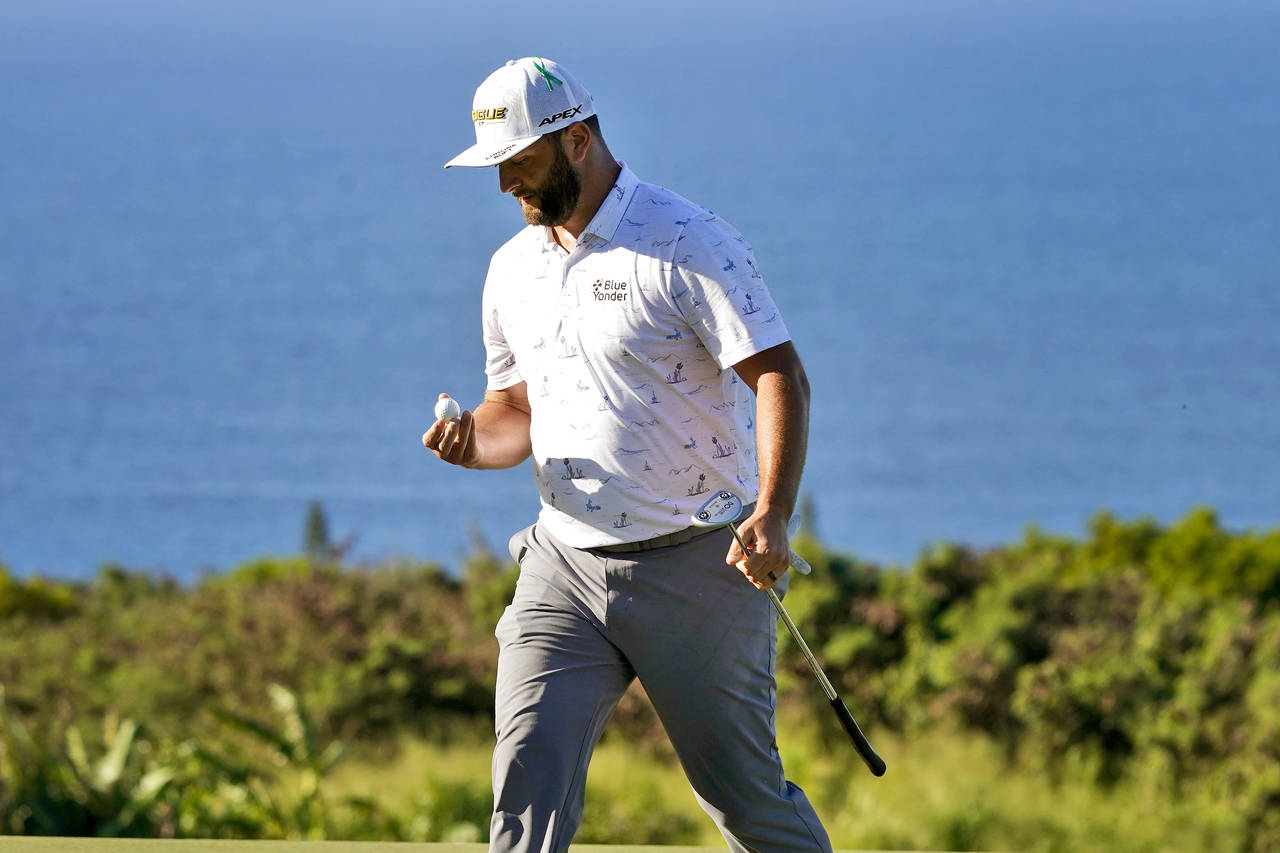 Jon Rahm, of Spain, looks at his ball after birding the 14th hole during the third round of the Tou...