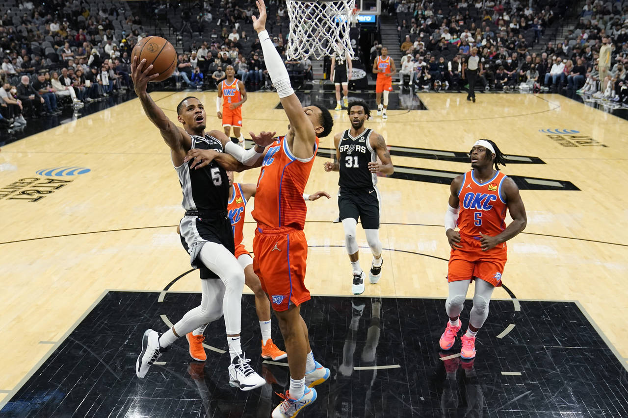 San Antonio Spurs guard Dejounte Murray (5) drives to the basket against Oklahoma City Thunder forw...