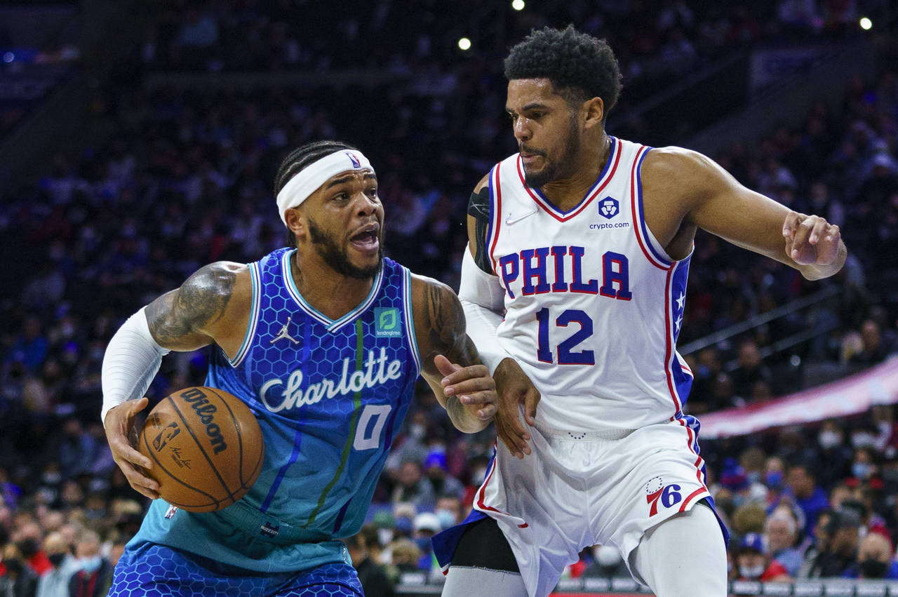 Charlotte Hornets' Miles Bridges, left, drives to the basket against Philadelphia 76ers' Tobias Har...