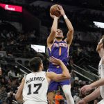 
              Phoenix Suns guard Devin Booker (1) shoots against the San Antonio Spurs during the second half of an NBA basketball game, Monday, Jan. 17, 2022, in San Antonio. (AP Photo/Eric Gay)
            