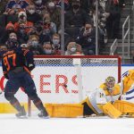 
              Nashville Predators' goalie Juuse Saros (74) is scored on by Edmonton Oilers' Connor McDavid (97) during the shootout of an NHL hockey game, Thursday, Jan. 27, 2022 in Edmonton, Alberta. (Jason Franson/The Canadian Press via AP)
            
