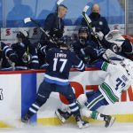 
              Winnipeg Jets' Adam Lowry (17) checks Vancouver Canucks' Brad Hunt (77) during second-period NHL hockey game action in Winnipeg, Manitoba, Thursday, Jan. 27, 2022. (John Woods/The Canadian Press via AP)
            