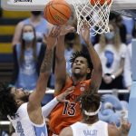 
              Virginia Tech guard Darius Maddox (13) defends while North Carolina guard R.J. Davis (4) shoots during the second half of an NCAA college basketball game in Chapel Hill, N.C., Monday, Jan. 24, 2022. (AP Photo/Gerry Broome)
            