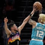 
              Phoenix Suns guard Devin Booker blocks a shot by Charlotte Hornets guard Kelly Oubre Jr. during the first half of an NBA basketball game on Sunday, Jan. 2, 2022, in Charlotte, N.C. (AP Photo/Chris Carlson)
            