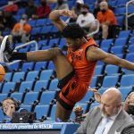 
              Oregon State guard Dexter Akanno jumps over the scorer's table as he goes after a loose ball during the first half of an NCAA college basketball game against UCLA Saturday, Jan. 15, 2022, in Los Angeles. (AP Photo/Mark J. Terrill)
            