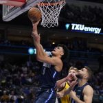 
              Dallas Mavericks guard Josh Green (8) goes up for a shot in front o forward Maxi Kleber, front right, and Indiana Pacers' Domantas Sabonis, center rear, in the first half of an NBA basketball game in Dallas, Saturday, Jan. 29, 2022. (AP Photo/Tony Gutierrez)
            