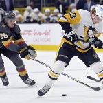 
              Vegas Golden Knights center Mattias Janmark (26) reaches to steal the puck from under Pittsburgh Penguins left wing Brock McGinn (23) during the first period of an NHL hockey game Monday, Jan. 17, 2022, in Las Vegas. (AP Photo/David Becker)
            