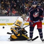 
              Pittsburgh Penguins goalie Tristan Jarry, left, stops a shot next to Columbus Blue Jackets forward Oliver Bjorkstrand during the second period of an NHL hockey game in Columbus, Ohio, Friday, Jan. 21, 2022. (AP Photo/Paul Vernon)
            