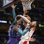 
              Washington Wizards forward Kyle Kuzma, right, goes to the basket against Charlotte Hornets forward Jalen McDaniels (6) and forward Miles Bridges (0) during the first half of an NBA basketball game, Monday, Jan. 3, 2022, in Washington. (AP Photo/Nick Wass)
            