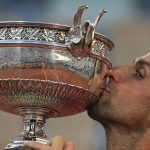 
              FILE - Serbia's Novak Djokovic kisses the cup after defeating Stefanos Tsitsipas of Greece during their final match of the French Open tennis tournament at the Roland Garros stadium Sunday, June 13, 2021 in Paris. Top-ranked player Novak Djokovic could be allowed to defend his French Open title under the latest COVID-19 rules adopted by the French government, even if he still not vaccinated when the clay-court Grand Slam starts in May. (AP Photo/Michel Euler, File)
            
