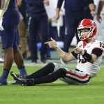 
              Georgia Bulldogs quarterback Stetson Bennett (13) shoots his guns after a quarterback keeper in the 4th quarter of the 2021 College Football Playoff Semifinal between the Georgia Bulldogs and the Michigan Wolverines at the Orange Bowl at Hard Rock Stadium in Miami Gardens. (Curtis Compton/Atlanta Journal-Constitution via AP)
            