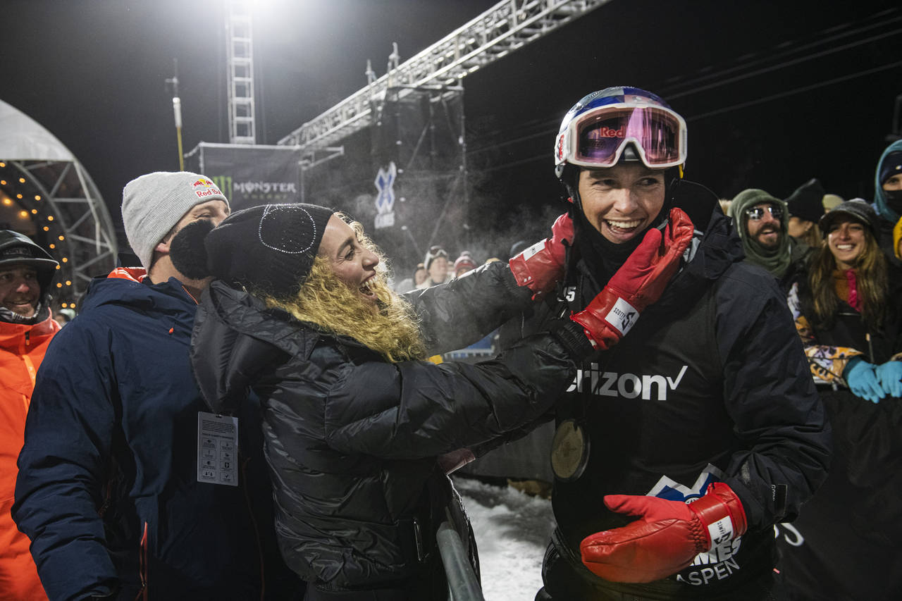 Scotty James celebrates with his fiancé Chloe Stroll after winning a gold medal in men's snowboard...