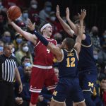 
              Rutgers guard Paul Mulcahy (4) is pressured by Michigan guard DeVante' Jones (12) and center Hunter Dickinson (1) during the first half of an NCAA college basketball game Tuesday, Jan. 4, 2022, in Piscataway, N.J. (Andrew Mills/NJ Advance Media via AP)
            