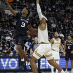 
              Butler guard Chuck Harris (3) drives to the basket past Providence center Nate Watson (0) during the second half of an NCAA college basketball game, Sunday, Jan. 23, 2022, in Providence, R.I. (AP Photo/Mary Schwalm)
            