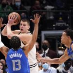 
              Denver Nuggets center Nikola Jokic, center, looks to pass against Dallas Mavericks guard Jalen Brunson (13) and center Dwight Powell (7) during the first quarter of an NBA basketball game in Dallas, Monday, Jan. 3, 2022. (AP Photo/LM Otero)
            