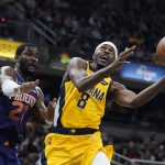 
              Indiana Pacers' Justin Holiday (8) looks to shoot against Phoenix Suns' Deandre Ayton (22) during the first half of an NBA basketball game, Friday, Jan. 14, 2022, in Indianapolis. (AP Photo/Darron Cummings)
            