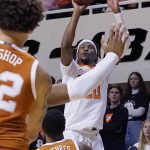 
              Oklahoma State guard Keylan Boone, right, shoots over Texas guard Jase Febres (13) and forward Christian Bishop, left, in the second half of an NCAA college basketball game Saturday, Jan. 8, 2022, in Stillwater, Okla. (AP Photo/Sue Ogrocki)
            