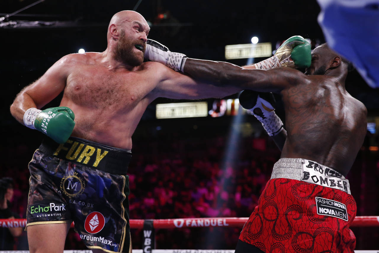 FILE - Tyson Fury, of England, hits Deontay Wilder in a heavyweight championship boxing match on Oc...