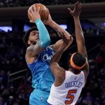 
              Charlotte Hornets forward Miles Bridges (0) shoots against New York Knicks guard Immanuel Quickley (5) during the first half of an NBA basketball game, Monday, Jan. 17, 2022, in New York. (AP Photo/John Minchillo)
            