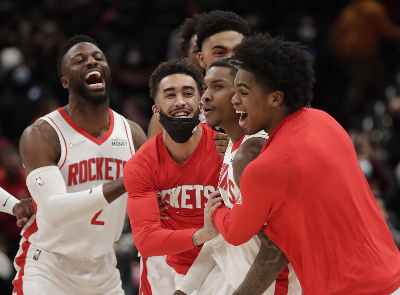 Houston Rockets' Kevin Porter Jr., second from right, celebrates with teammates after making the ga...