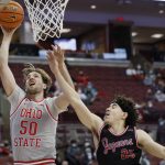 
              Ohio State's Joey Brunk, left, shoots next to IUPUI's Boston Stanton during the second half of an NCAA college basketball game Tuesday, Jan. 18, 2022, in Columbus, Ohio. (AP Photo/Jay LaPrete)
            