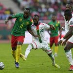 
              Cameroon's Moumi Ngamaleu, left, is challenged by Burkina Faso's Eric Traore during the African Cup of Nations 2022 group A soccer match between Cameroon and Burkina Faso at the Olembe stadium in Yaounde, Cameroon, Sunday, Jan. 9, 2022. (AP Photo/Themba Hadebe)
            