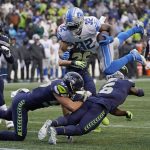 
              Detroit Lions running back D'Andre Swift leaps over Seattle Seahawks linebacker Cody Barton (57) and free safety Quandre Diggs (6) near the goal line during the second half of an NFL football game, Sunday, Jan. 2, 2022, in Seattle. (AP Photo/Elaine Thompson)
            