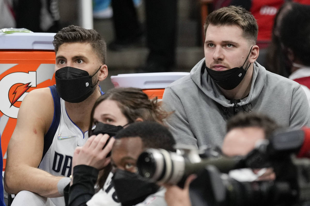Dallas Mavericks guard Luka Doncic, right, watches from the bench during the second half of the tea...