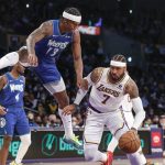
              Los Angeles Lakers forward Carmelo Anthony drives as Minnesota Timberwolves forward Nathan Knight (13) gets airborne on a fake during the first half of an NBA basketball game in Los Angeles, Sunday, Jan. 2, 2022. (AP Photo/Ringo H.W. Chiu)
            