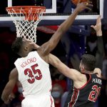 
              Arizona center Christian Koloko (35) gets a block despite a hand in the face by Utah forward Dusan Mahorcic (21) in the first half of an NCAA college basketball game in Tucson, Ariz., Saturday, Jan. 15, 2022. (Kelly Presnell/Arizona Daily Star via AP)
            