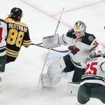 
              Boston Bruins' David Pastrnak (88) goes for the puck as it rebounds off the crossbar behind Minnesota Wild's Kaapo Kahkonen (34) during the first period of an NHL hockey game Thursday, Jan. 6, 2022, in Boston. (AP Photo/Michael Dwyer)
            