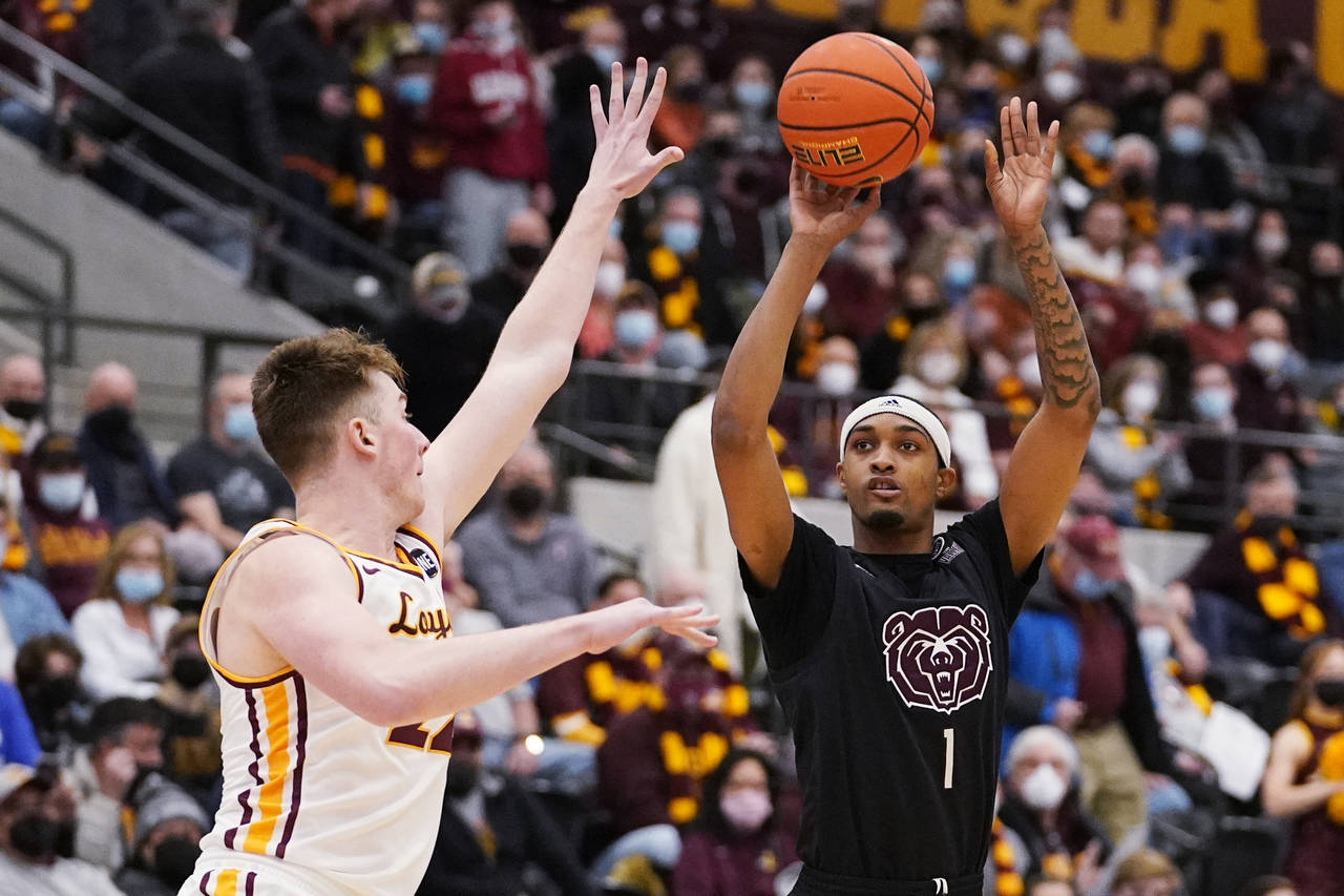 Missouri State guard Isiaih Mosley, right, shoots over Loyola Chicago center Jacob Hutson during th...